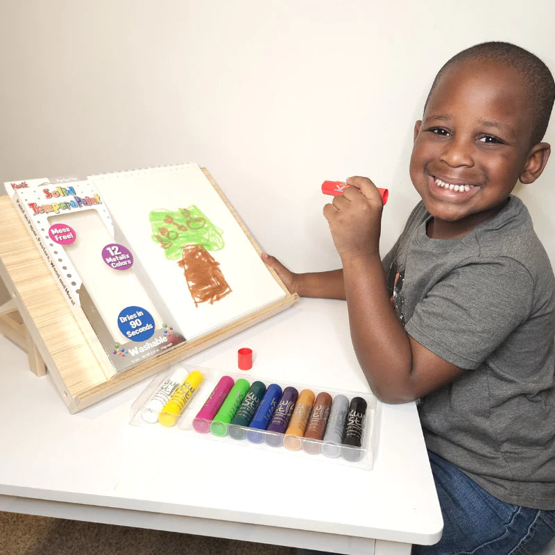 kid drawing with kwik stix on paper