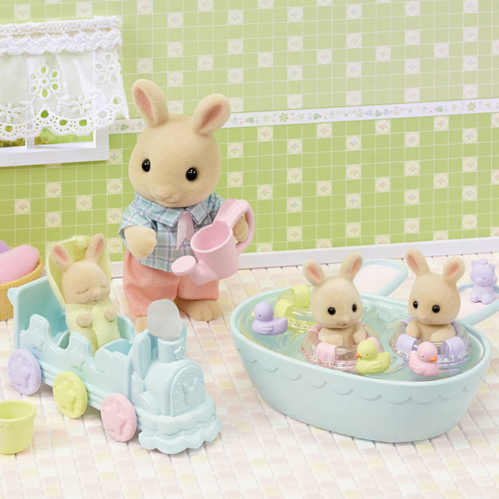 Milk rabbit triplets in bathtub with toys along with father rabbit and choo choo train