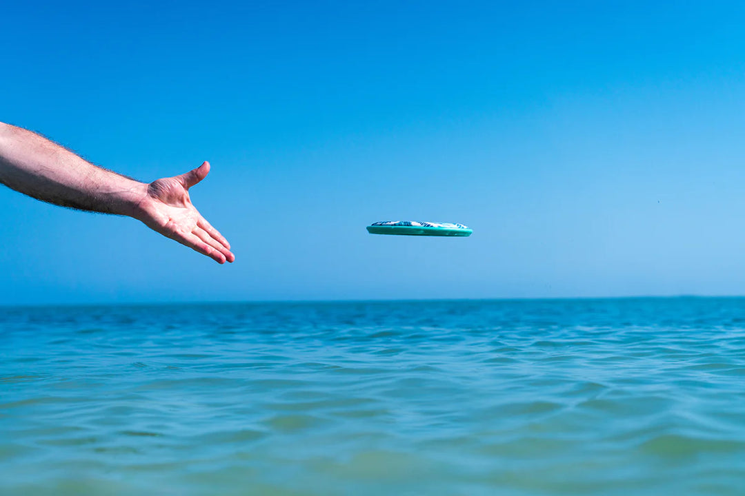 hand throwing flobo in the ocean