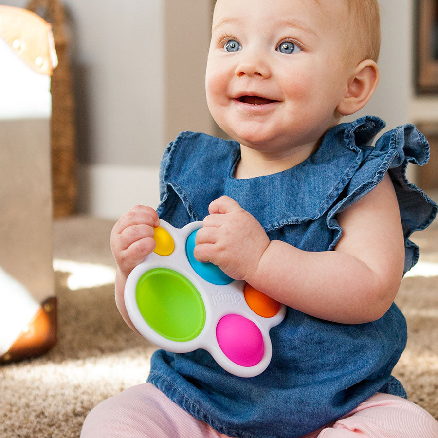 baby holding dimpl toy