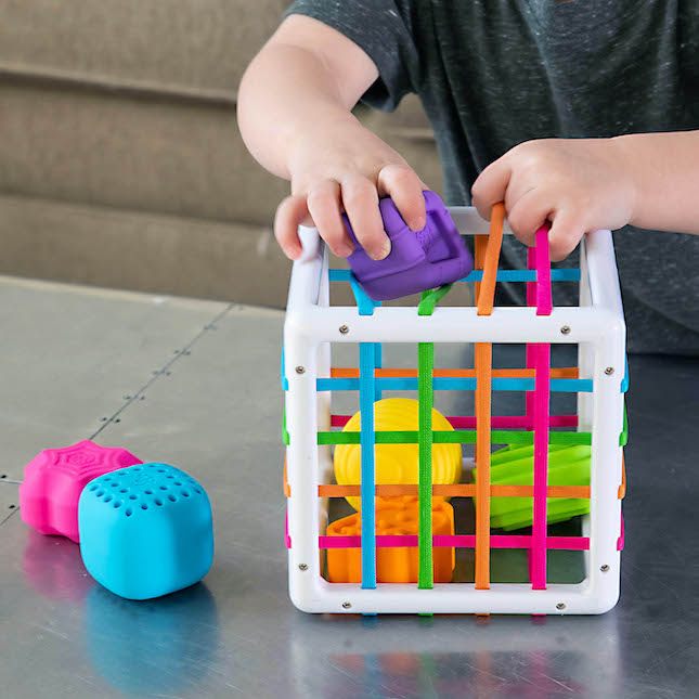 Kid playing with InnyBin- some pieces inside some out