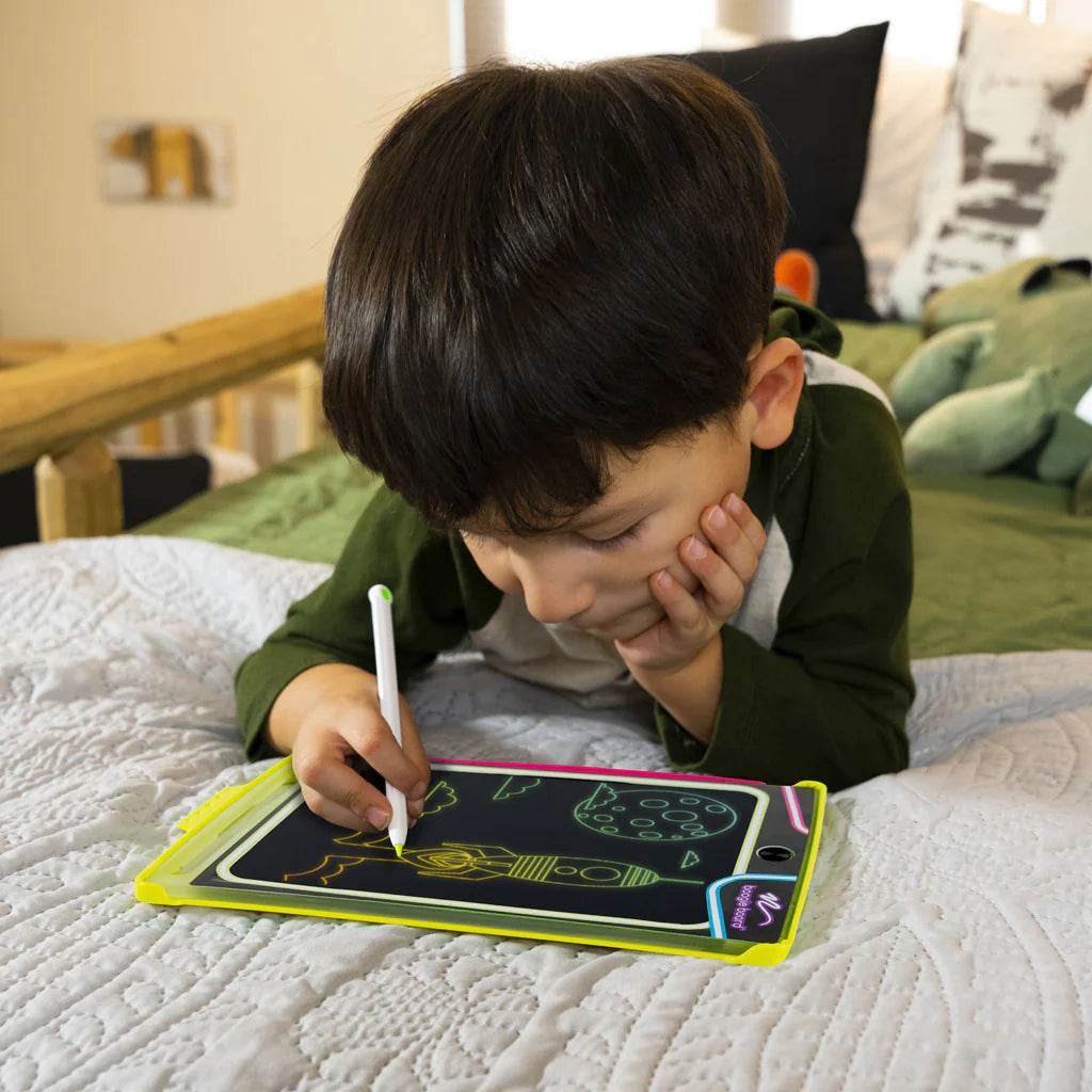 Child drawing on board laying in bed