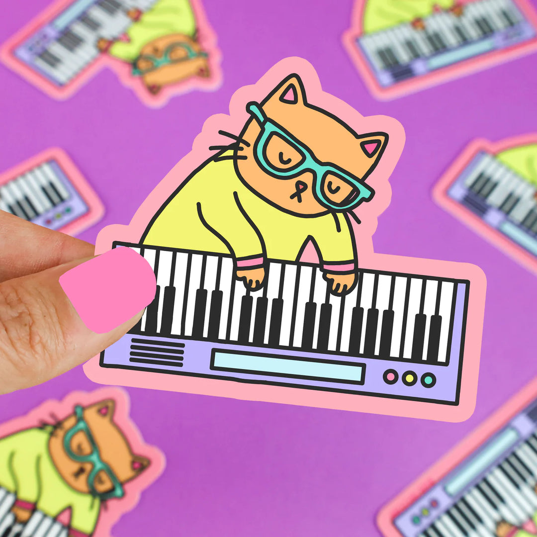 keyboard cat sticker being held above purple background