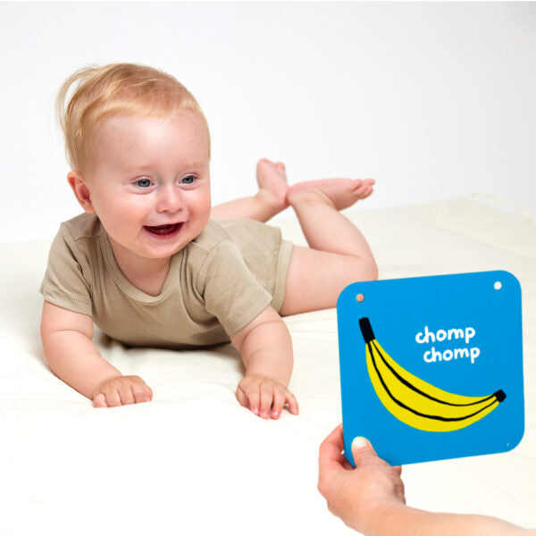 baby on tummy smiling at card