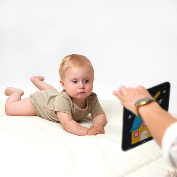 serious baby looking at card