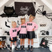 three girls in fun halloween background all wearing pink sweatshirts with black BOO patch and black skirts
