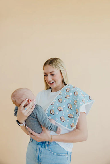 woman holding baby with burp cloth on shoulder to demonstrate size
