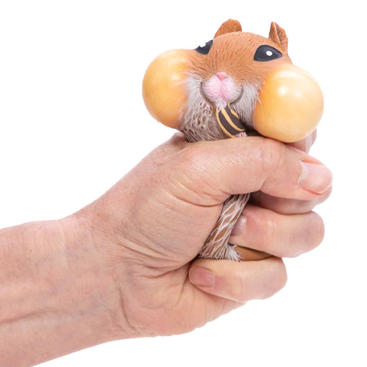 hand squeezing brown hamster