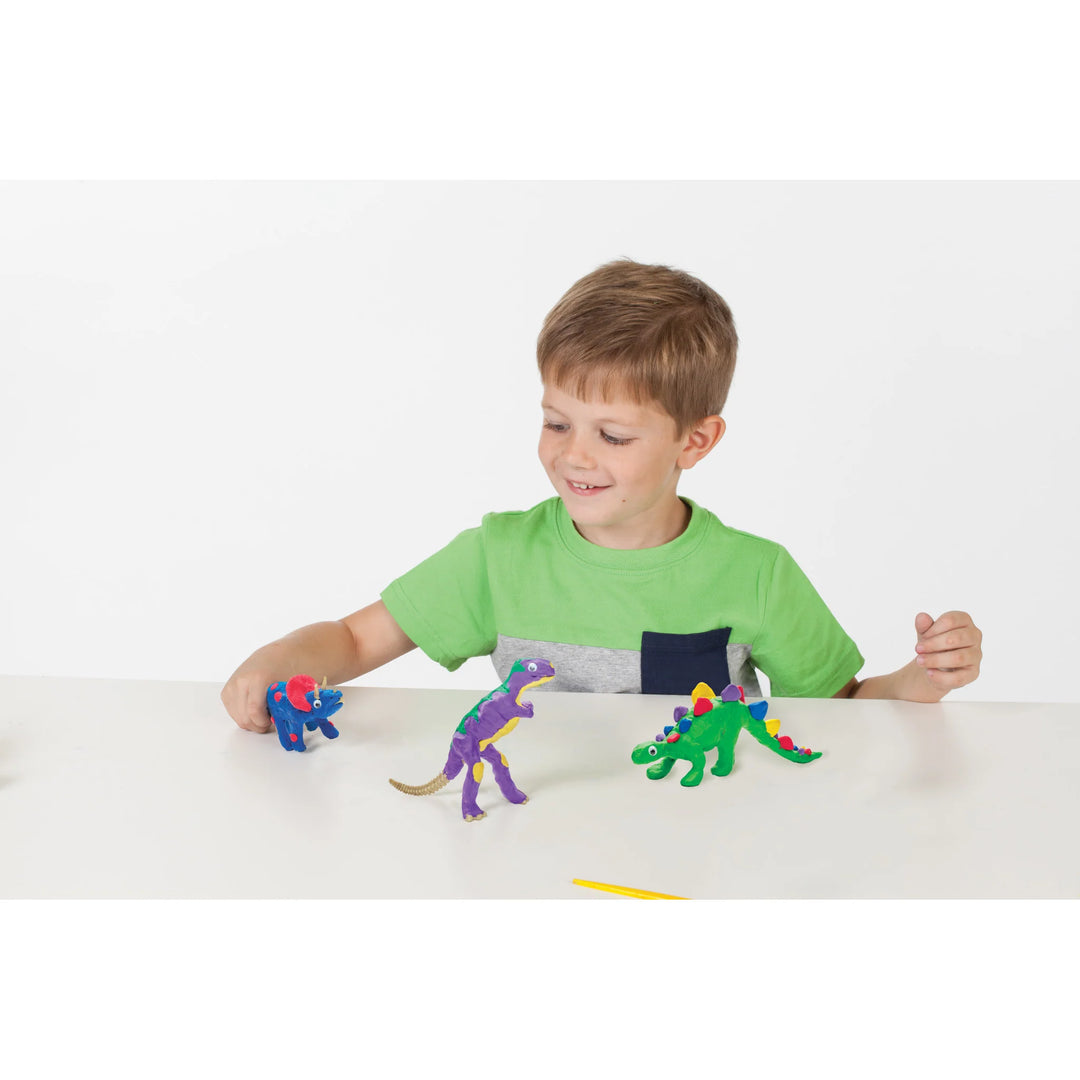 little boy playing with clay dinosaurs