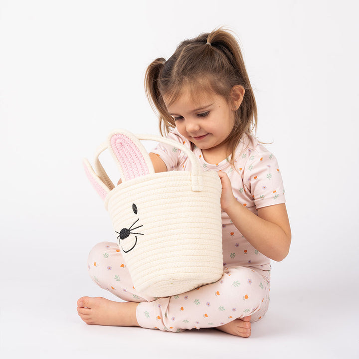little girl sitting with cream basket