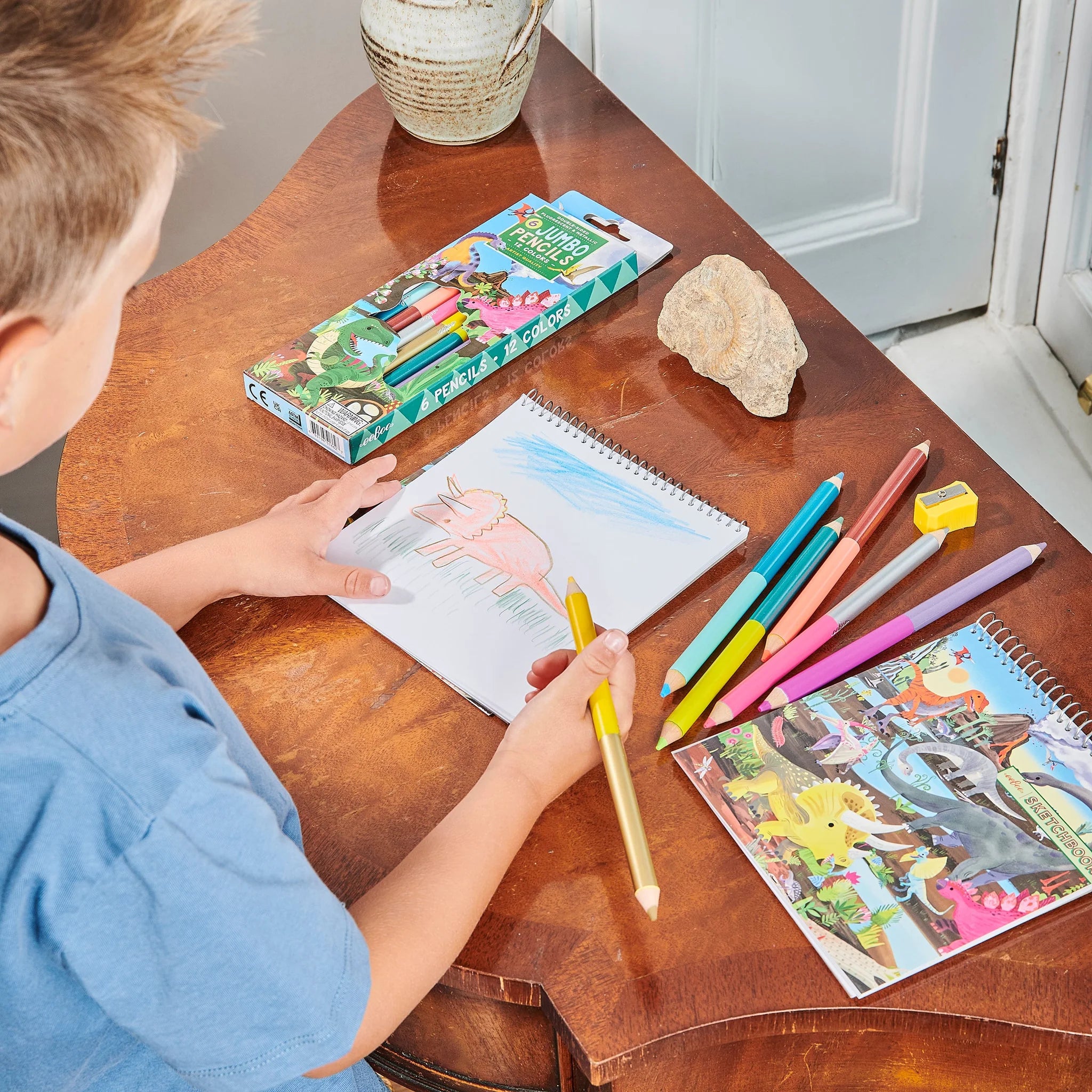 kid drawing with colored pencils