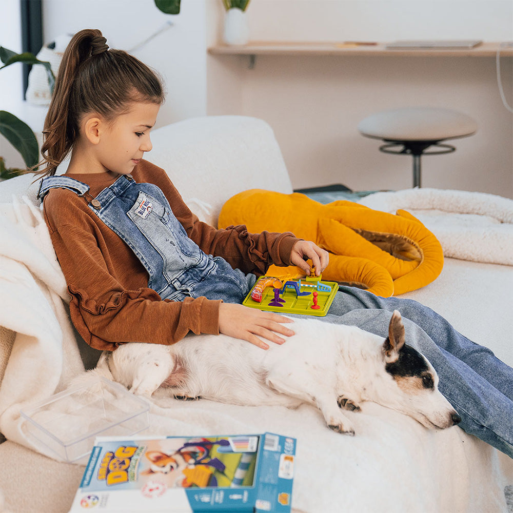 girl sitting with dog playing game