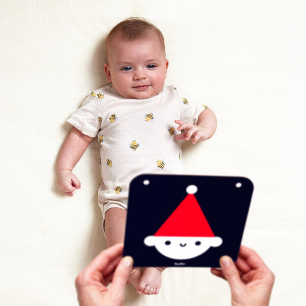infant on back smiling at baby card