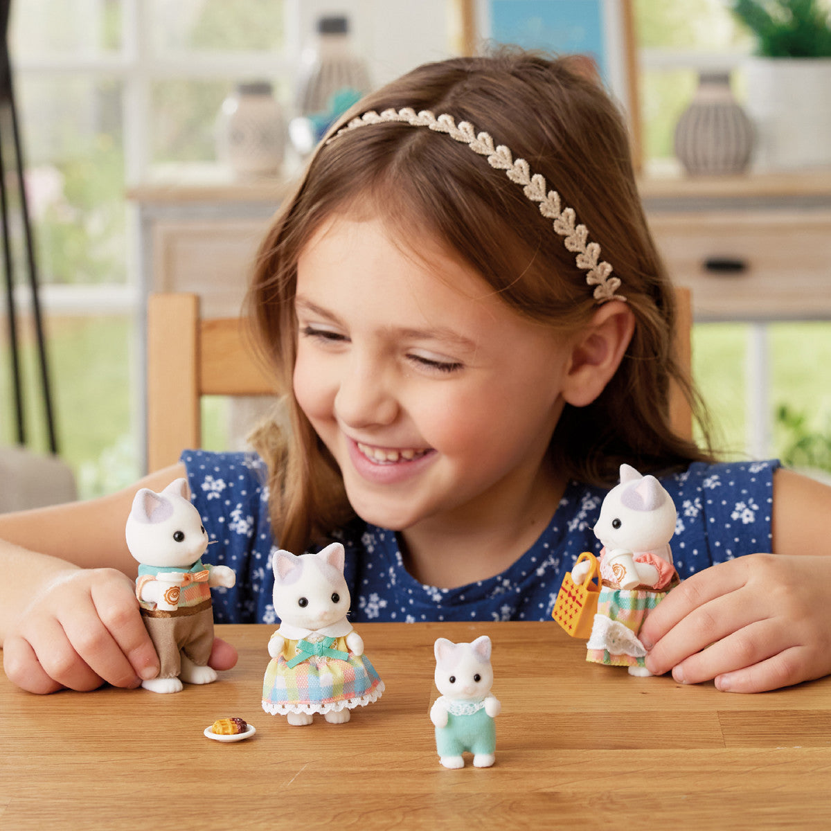 little girl playing with latte cat family