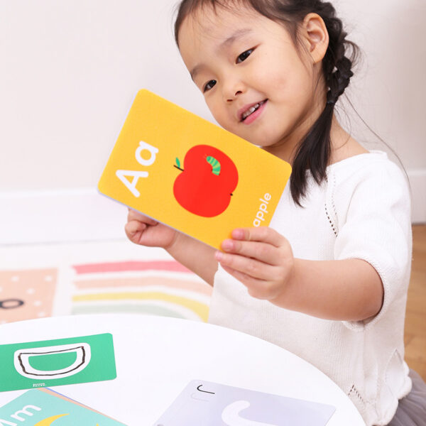 girl reading flash card while seated at table