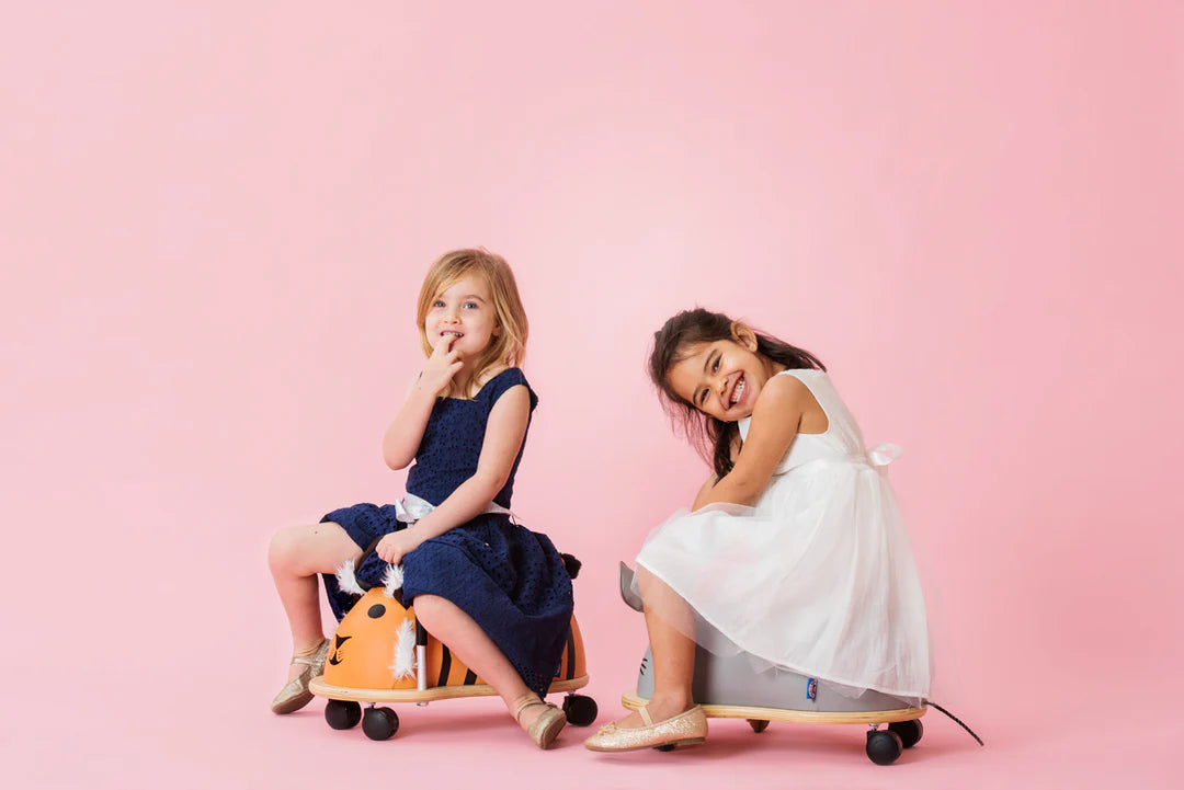 kids sitting on wheely bugs