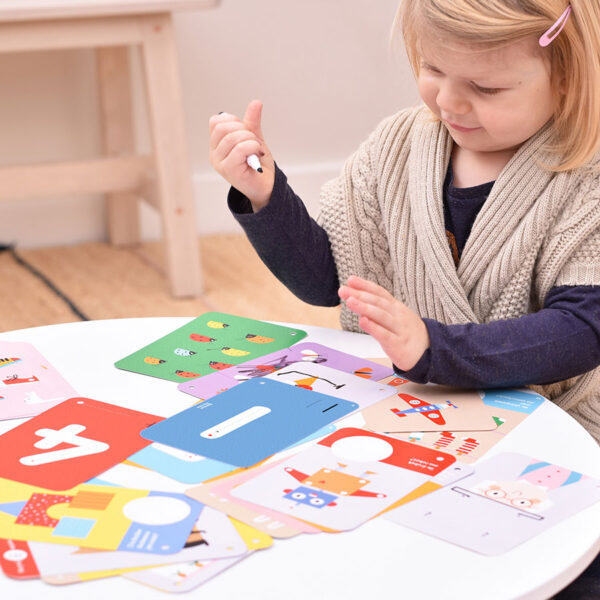 girl seated at table writing on flash cards