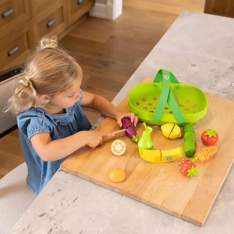 little girl playing with pretendables fruit and veggie basket