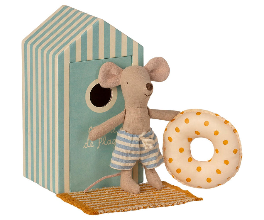 Beach mouse standing in front of box holding inner tube and towel