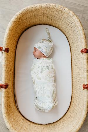 baby swaddled in blanket and wearing matching hat